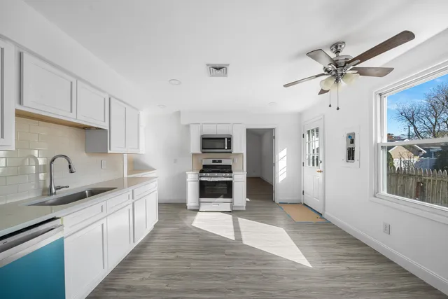 a kitchen with granite countertop a stove a sink and a refrigerator