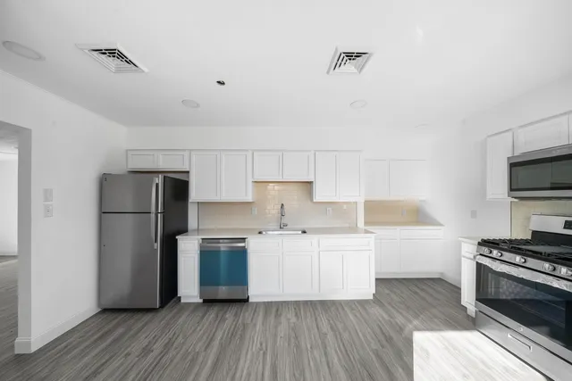 a kitchen with a refrigerator and a stove top oven