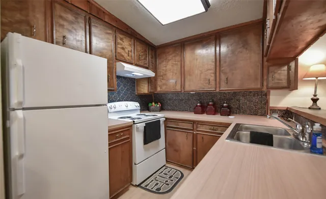 a kitchen with a refrigerator sink and stove