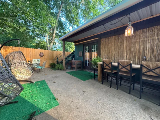 a view of a patio with table and chairs with wooden floor and fence