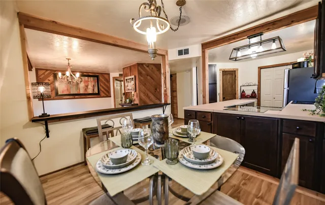 a view of a dining room with furniture a chandelier and wooden floor