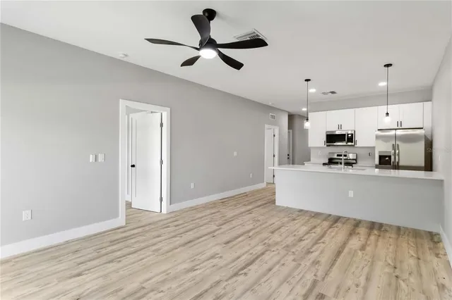a view of kitchen with stainless steel appliances refrigerator stove microwave and cabinets