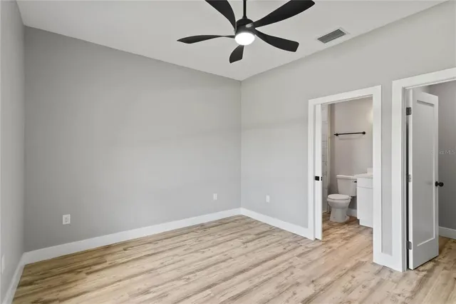 a view of an empty room and window and wooden floor