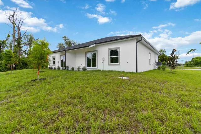 a white house sitting in middle of the green field