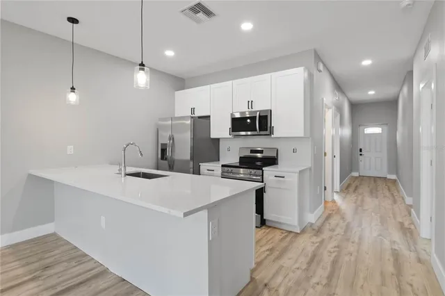 a kitchen with kitchen island a sink stainless steel appliances and cabinets