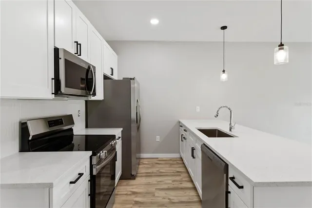 a kitchen with stainless steel appliances granite countertop a sink a stove and a refrigerator