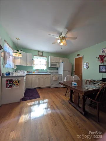 a living room with stainless steel appliances kitchen island granite countertop furniture wooden floor and a view of kitchen