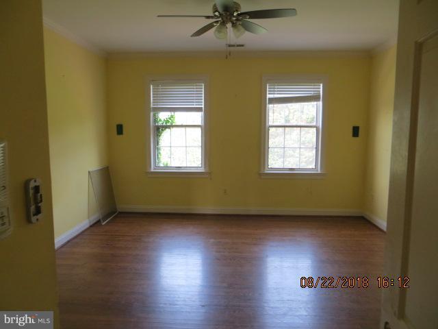15621 Holly Grove Road Silver Spring, MD 20905 - Photo 14 of 21 a view of an empty room with a window and wooden floor