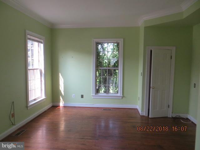 15621 Holly Grove Road Silver Spring, MD 20905 - Photo 7 of 21 an empty room with wooden floor and windows