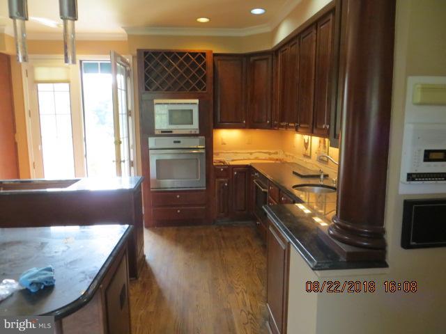 15621 Holly Grove Road Silver Spring, MD 20905 - Photo 9 of 21 a kitchen with stainless steel appliances granite countertop a stove a sink and a microwave