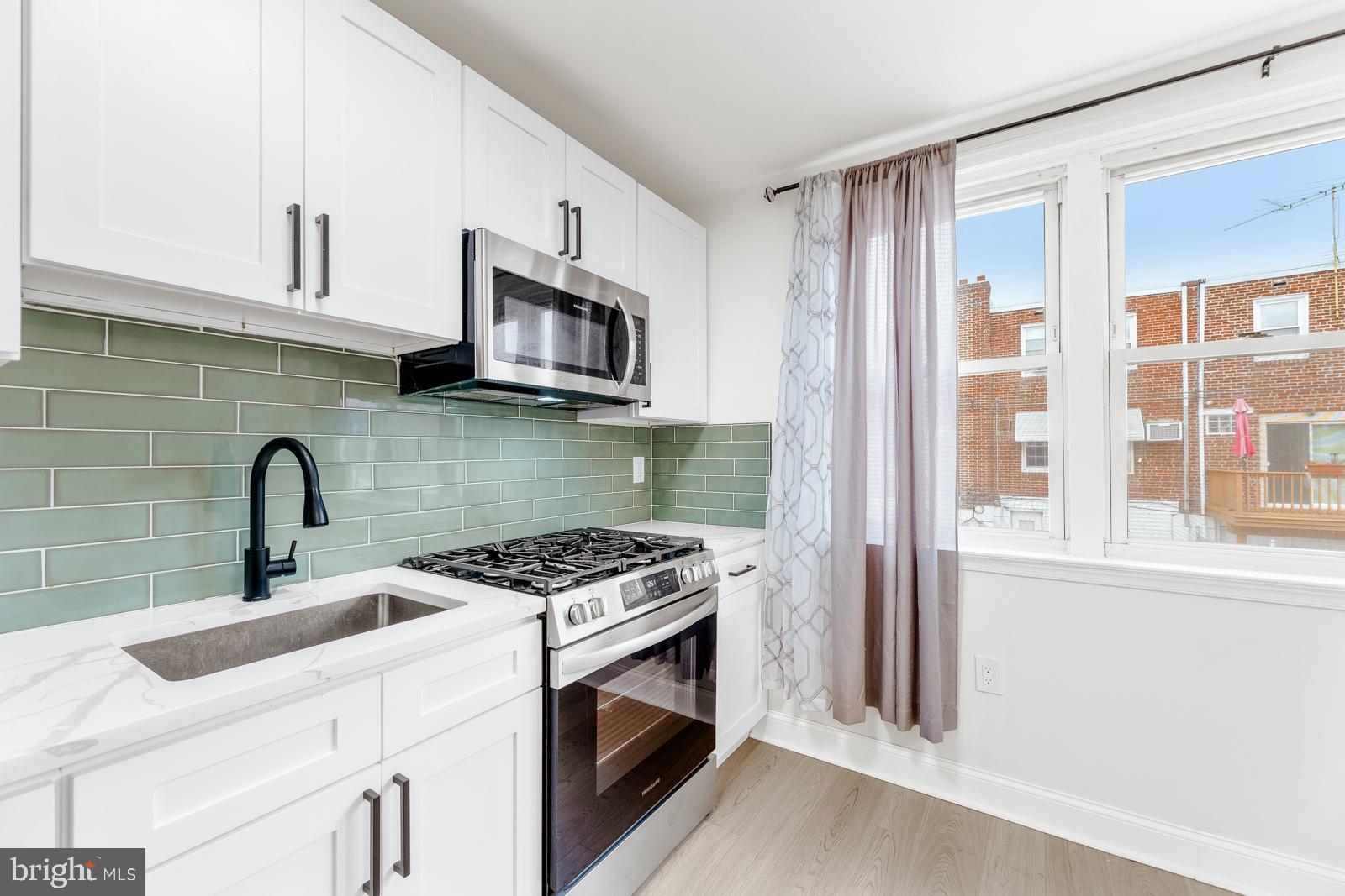 6302 Hegerman Street Philadelphia, PA 19135 - Photo 11 of 26 a kitchen with stainless steel appliances granite countertop a stove a sink and a microwave