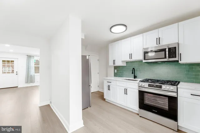 a kitchen with stainless steel appliances a stove a microwave and cabinets