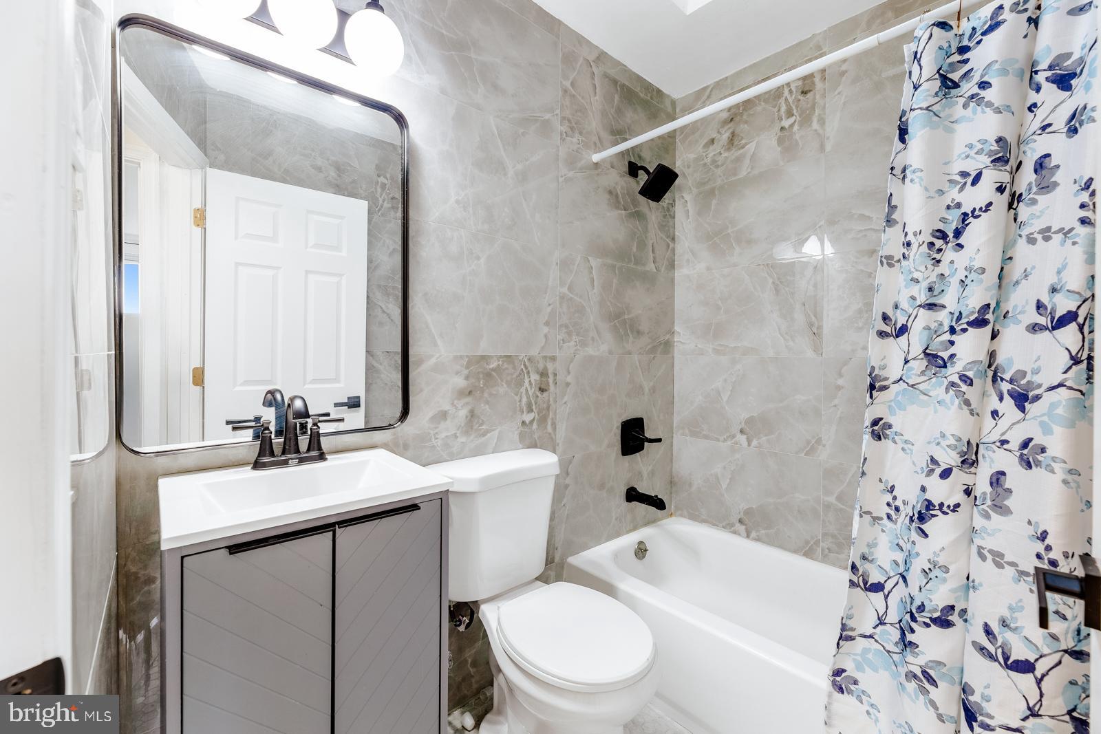 6302 Hegerman Street Philadelphia, PA 19135 - Photo 18 of 26 a bathroom with a sink a toilet and shower a mirror