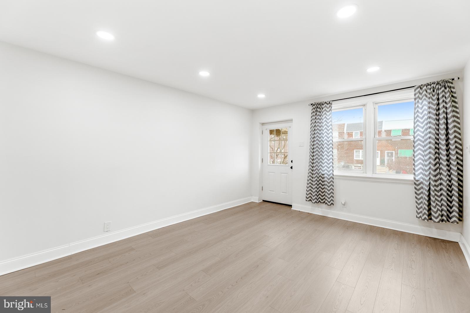 6302 Hegerman Street Philadelphia, PA 19135 - Photo 4 of 26 an empty room with wooden floor and windows