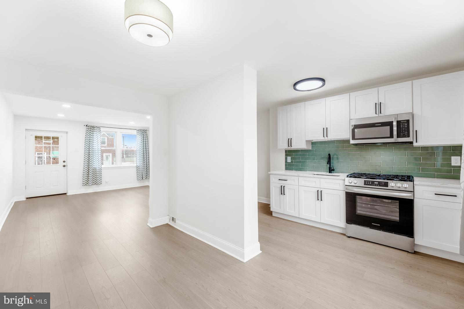 6302 Hegerman Street Philadelphia, PA 19135 - Photo 9 of 26 a kitchen with granite countertop a stove a sink and a refrigerator