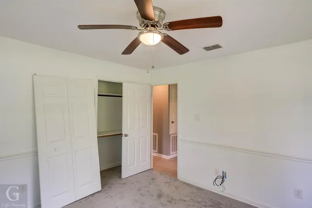 a view of empty room with ceiling fan