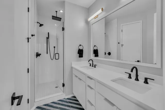 a bathroom with double vanity sink and mirror