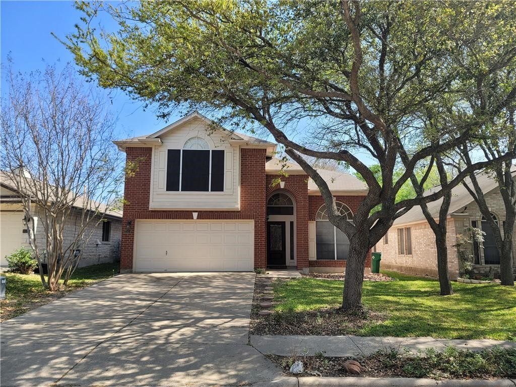 a front view of a house with a yard and trees