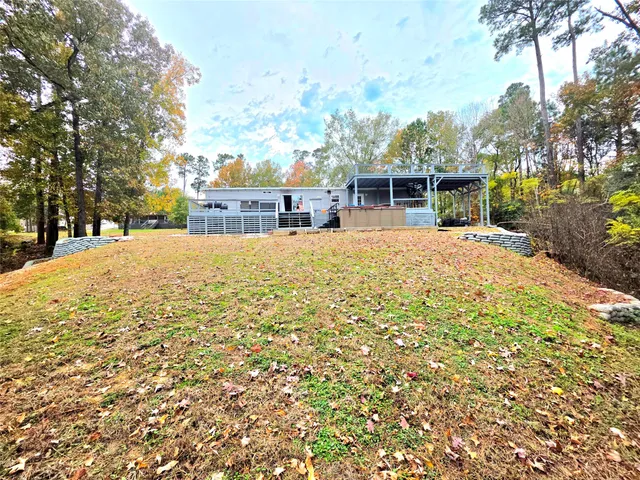 a front view of a house with a yard covered with snow and trees