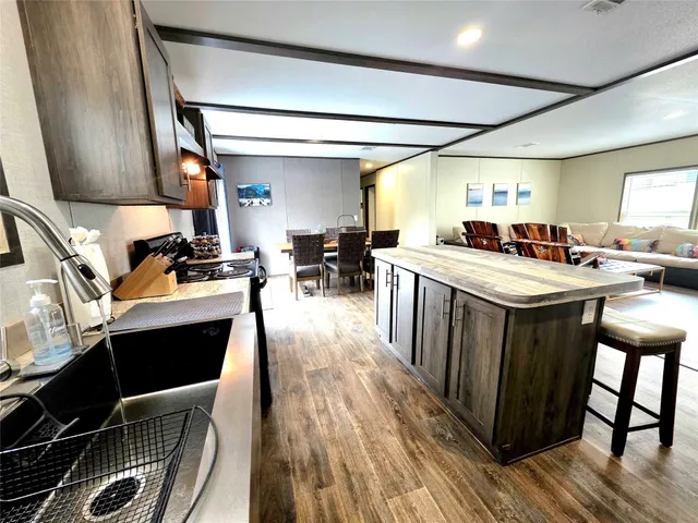 a kitchen with a stove a refrigerator and wooden floor