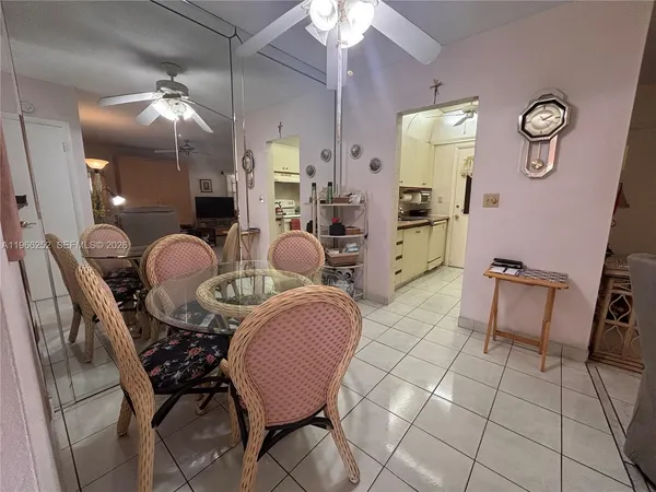 a dining room with furniture and a chandelier fan