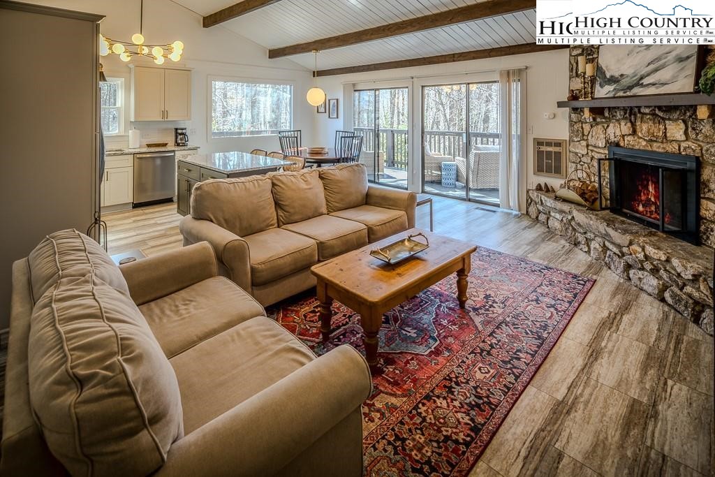 a living room with furniture a large window and a fireplace