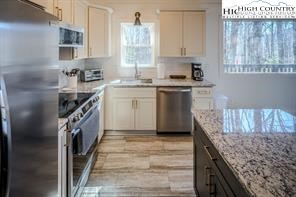 811 Pine Ridge Road Banner Elk, NC 28604 - Photo 11 of 35 a kitchen with granite countertop a sink stove and cabinets