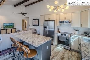 811 Pine Ridge Road Banner Elk, NC 28604 - Photo 10 of 35 a kitchen with stainless steel appliances granite countertop a kitchen island a stove a refrigerator a sink dishwasher a dining table and chairs with wooden floor