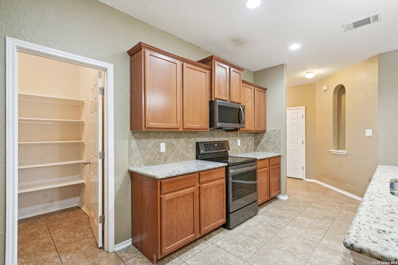 9536 Gold Stage Road San Antonio, TX 78254 - Photo 14 of 39 a kitchen with a sink stove and microwave