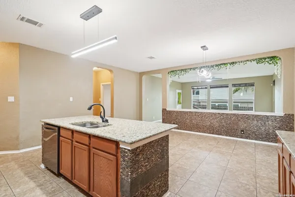 a hall with kitchen island a sink wooden floor and glass door