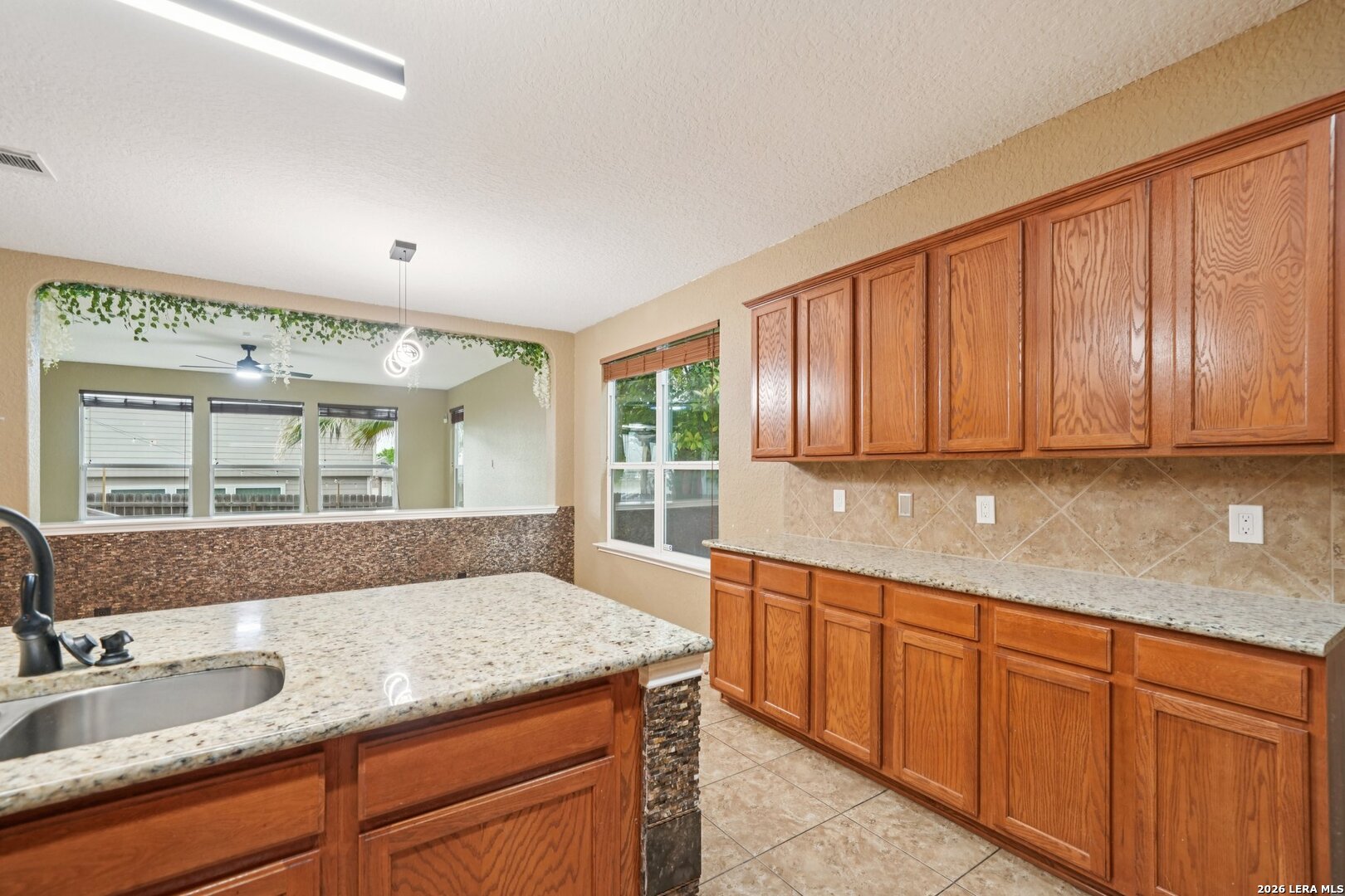 9536 Gold Stage Road San Antonio, TX 78254 - Photo 16 of 39 a bathroom with a granite countertop sink and a large mirror
