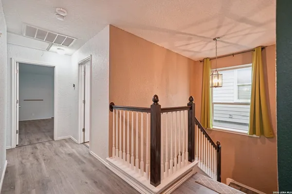 a view of a hallway with wooden floor and entryway