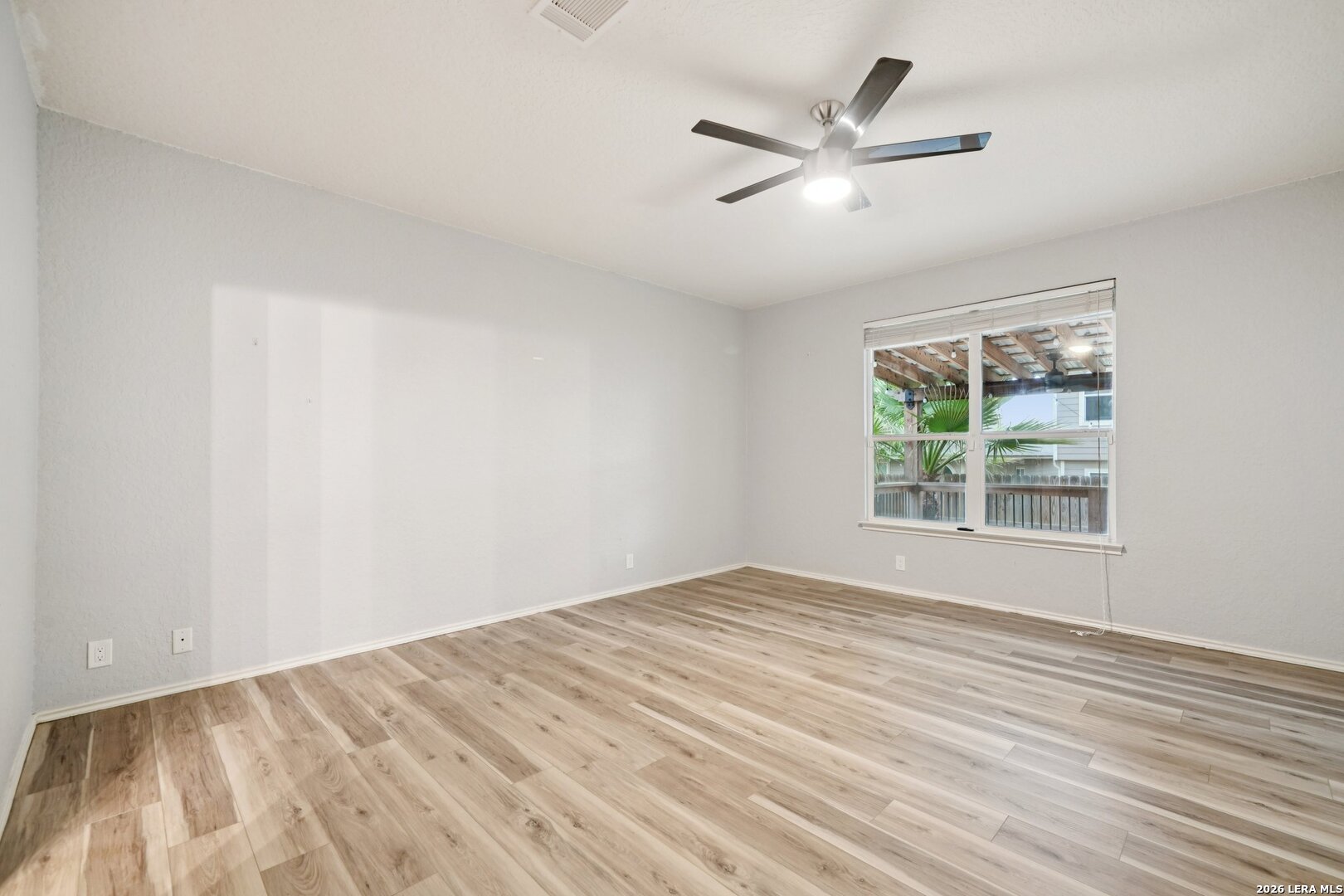 9536 Gold Stage Road San Antonio, TX 78254 - Photo 20 of 39 an empty room with wooden floor fan and windows