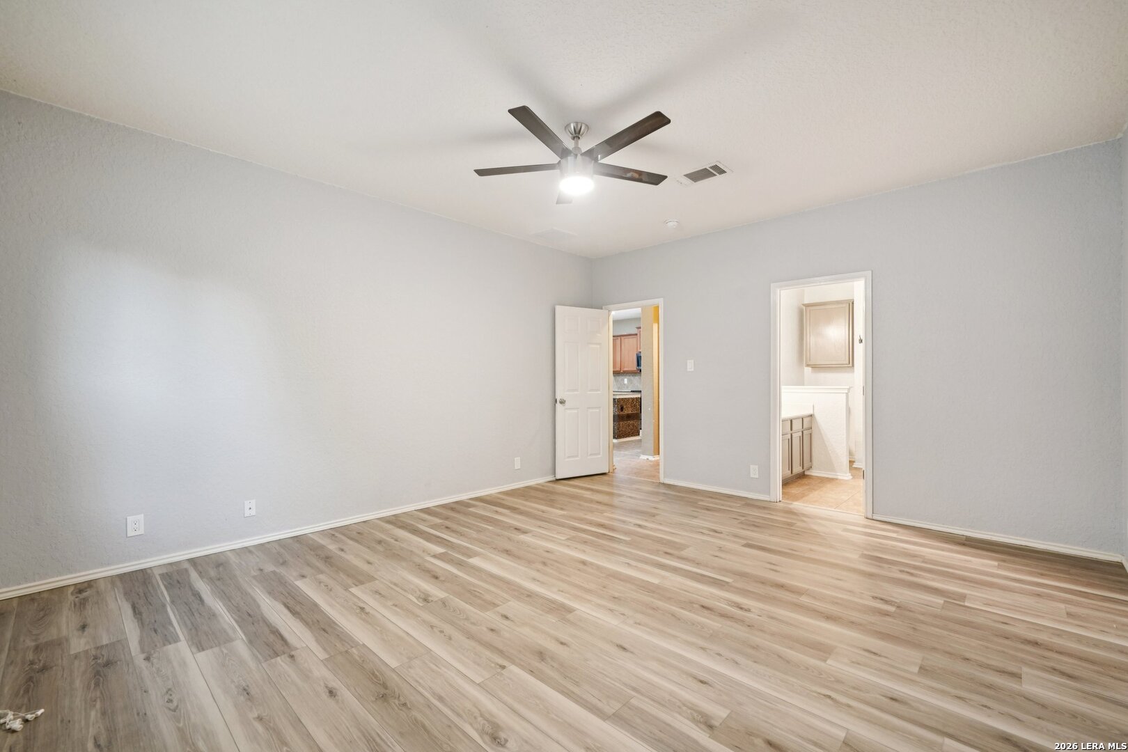 9536 Gold Stage Road San Antonio, TX 78254 - Photo 21 of 39 a view of an empty room with wooden floor and a ceiling fan