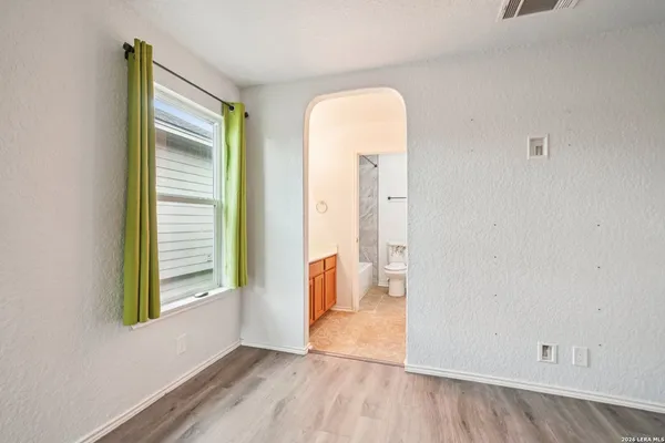 an empty room with a window and wooden floor