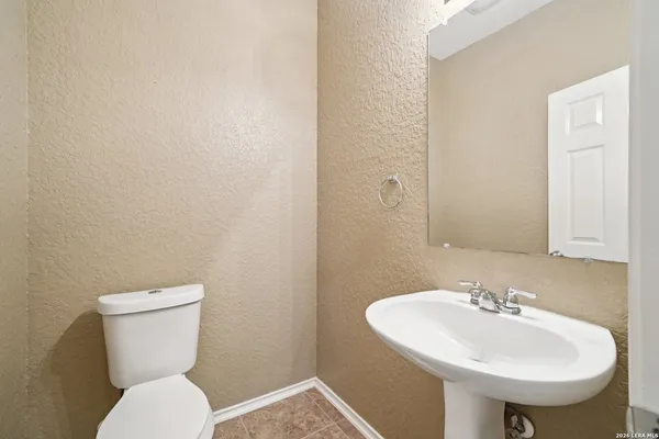 a bathroom with a toilet sink and mirror