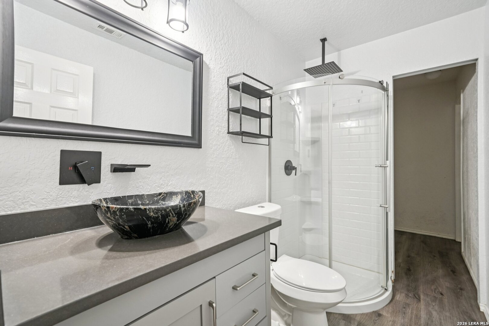 9536 Gold Stage Road San Antonio, TX 78254 - Photo 31 of 39 a bathroom with a granite countertop sink a toilet a mirror and shower