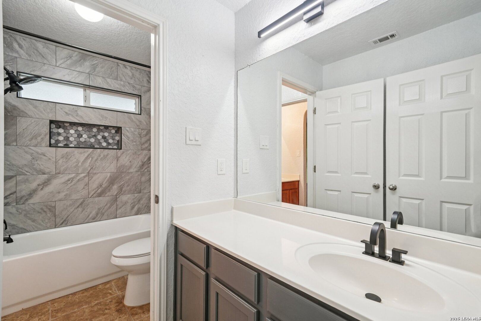 9536 Gold Stage Road San Antonio, TX 78254 - Photo 34 of 39 a bathroom with a sink a toilet and a large mirror