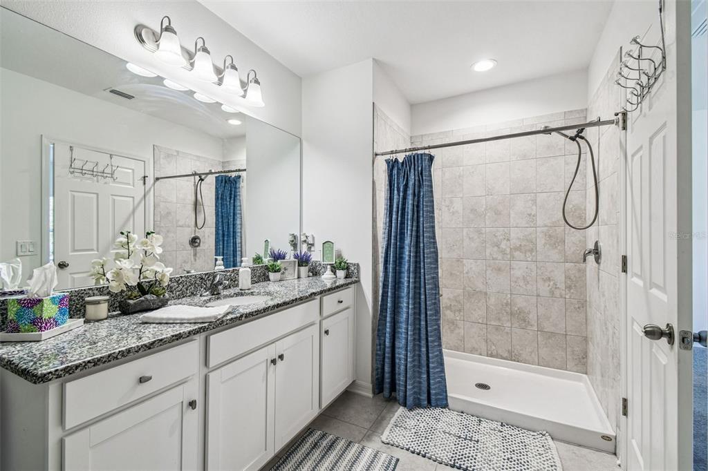 12907 Conquistador Loop Spring Hill, FL 34610 - Photo 48 of 74 a bathroom with a double vanity sink mirror and shower