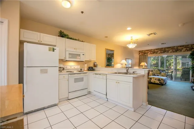 a kitchen with sink refrigerator and cabinets