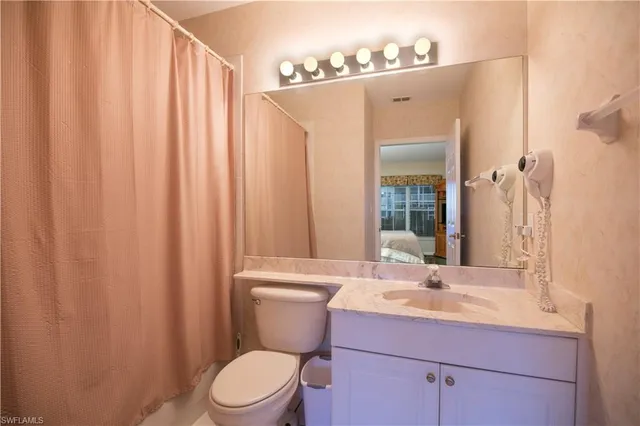 a bathroom with a sink a toilet and shower curtain