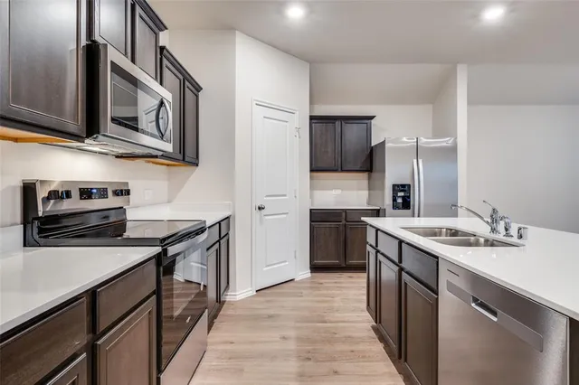 a kitchen with stainless steel appliances granite countertop a sink stove and refrigerator