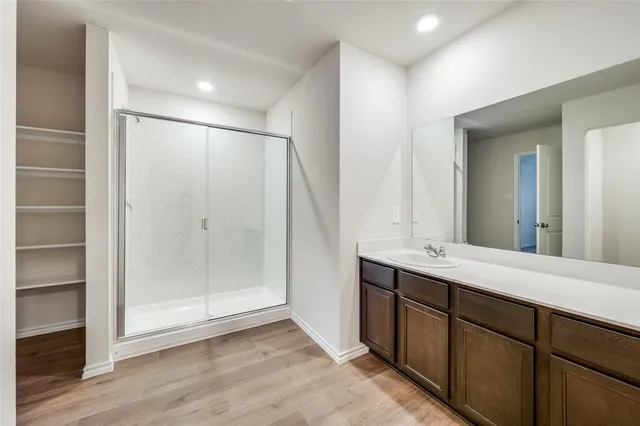 a bathroom with a shower sink and mirror