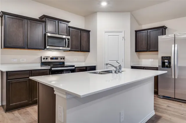 a kitchen with stainless steel appliances a sink microwave and refrigerator