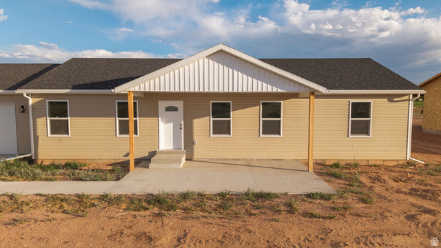 130 Pole Line Road, Unit 2 Roosevelt, UT 84066 - Photo 4 of 33 Ranch-style residence featuring tan horizontal siding, a dark shingle roof, and white-framed windows