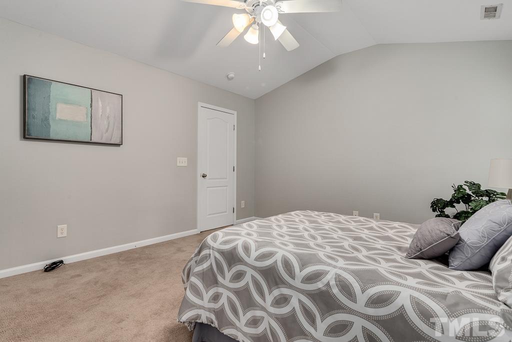 3122 Binghampton Lane Raleigh, NC 27604 - Photo 14 of 28 a bedroom with a bed and a chandelier