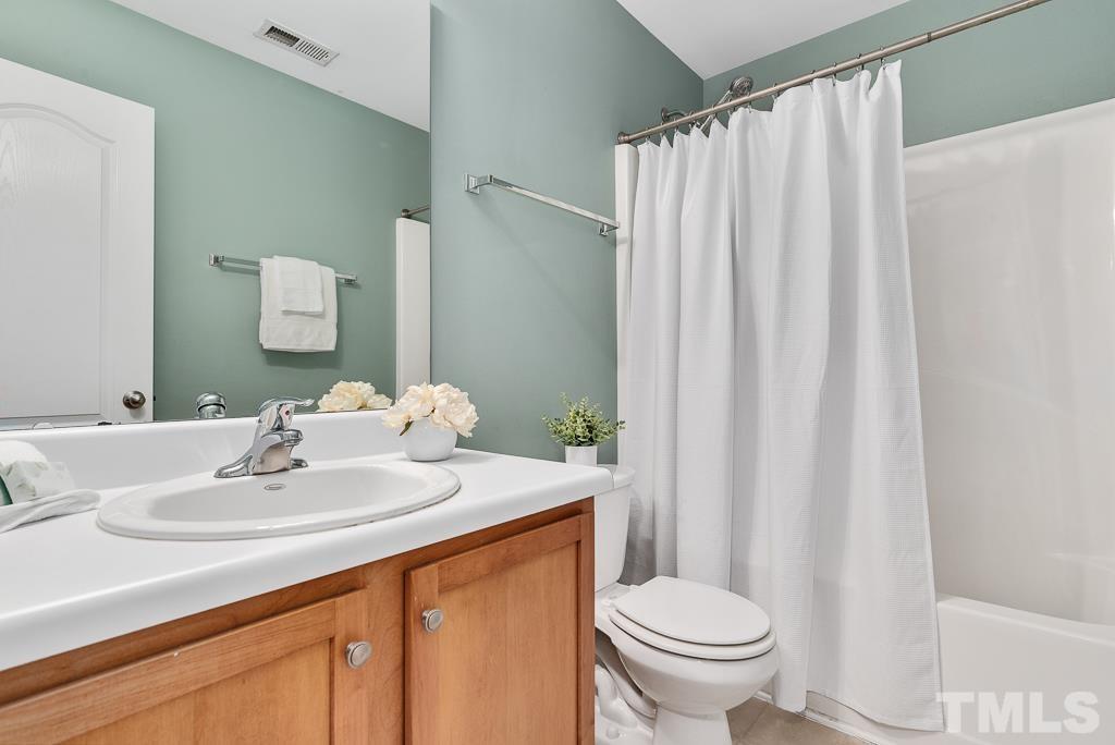3122 Binghampton Lane Raleigh, NC 27604 - Photo 23 of 28 a bathroom with a sink a toilet and shower curtain