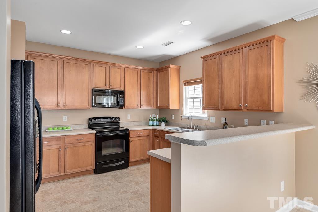 3122 Binghampton Lane Raleigh, NC 27604 - Photo 7 of 28 a kitchen with stainless steel appliances granite countertop white cabinets sink and window