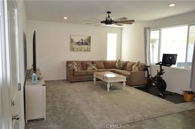 a living room with furniture a large window and a flat screen tv