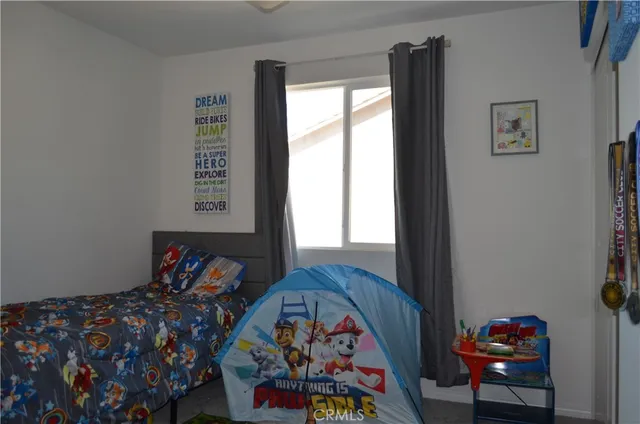 a bedroom with two beds and a dresser